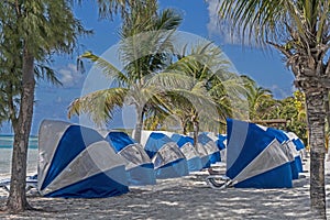 Blue and white umbrellas are placed in a row ready for tourists.