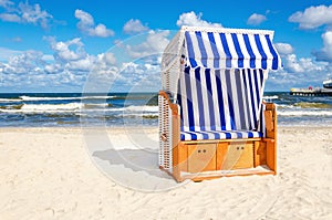 Blue and white wicker chair on sandy beach