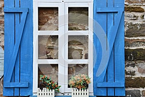 Blue and white wooden window frames of an old stone house