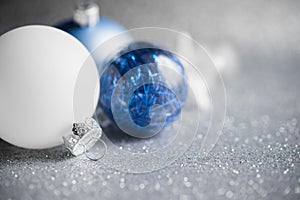 Blue and white xmas ornaments on glitter holiday background. Merry christmas card.