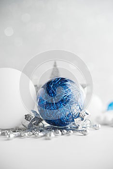 Blue and white xmas ornaments on glitter holiday background. Merry christmas card.