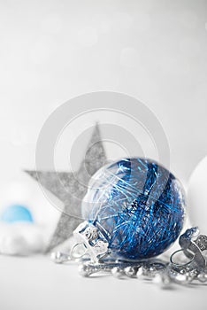 Blue and white xmas ornaments on glitter holiday background. Merry christmas card.