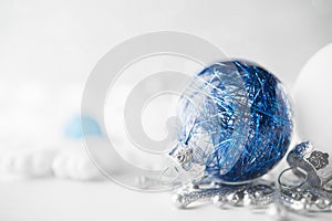 Blue and white xmas ornaments on glitter holiday background. Merry christmas card.