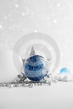 Blue and white xmas ornaments on glitter holiday background. Merry christmas card.