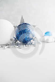 Blue and white xmas ornaments on glitter holiday background. Merry christmas card.