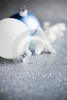 Blue and white xmas ornaments on glitter holiday background. Merry christmas card.