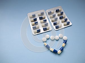 Blue and white with yellow medical pills and tablets in heart shape on a blue background with copy space