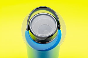 Blue Wide Mouth Insulated Stainless Steel Bottle with Wide Flat Cap isolated on bright yellow. BPA-Free. Double Wall Va