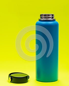 Blue Wide Mouth Insulated Stainless Steel Bottle with Wide Flat Cap isolated on bright yellow. BPA-Free. Double Wall Va