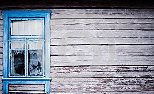 Blue window on house with peeling paint