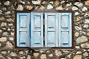 Blue window on stone wall