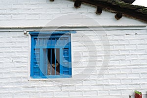 A blue window in a traditionally built house