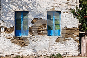 Blue windows of a ruined building in the port town of Korthi on the Greek Andros Island
