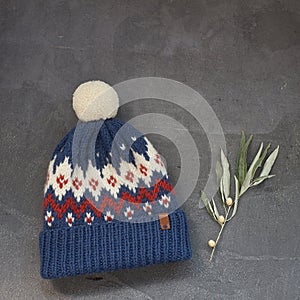 Blue winter hat with a jacquard pattern on a gray background
