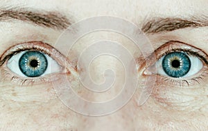 Blue women eyes close up. Girl portrait, closeup. Natural face with wrinlkes. Gazing woman. Skin care concept. photo