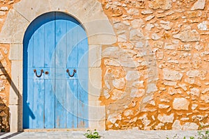 Blue wood door and rustic stone wall of mediterranean house