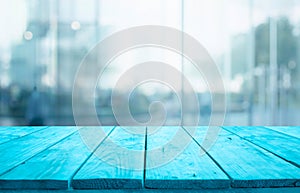 Blue wood table top on blur window glass,wall background