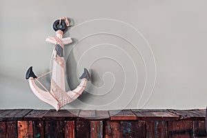 Blue wooden anchor decorated with rope