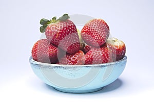Blue wooden bowl filled with strawberries