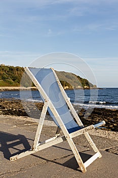 Blue wooden deckchair by the sea