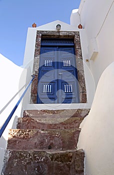 Blue wooden door in white house, Santorini island, Greece