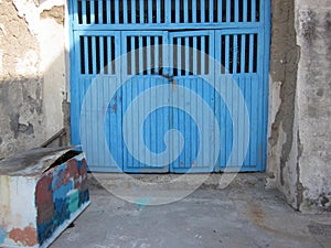 blue wooden garage doors and painted box in the streets of Procida Italy