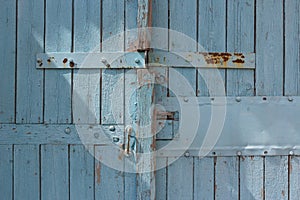 Blue wooden gate with strips from metal