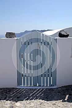 Blue wooden gates in white house, Santorini island, Greece