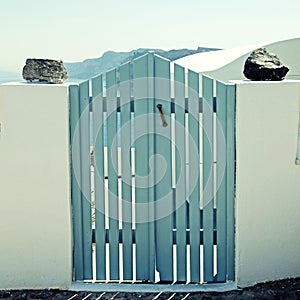 Blue wooden gates in white house, Santorini island, Greece