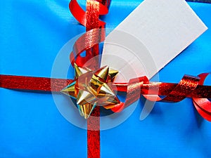 Blue wrapped gift with blank tag and pretty shiny ribbon