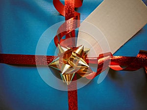 Blue wrapped gift with blank tag and pretty shiny ribbon