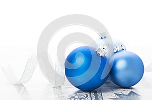 Blue xmas balls and silver ribbon on holiday background photo