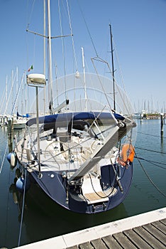 A blue yacht in the port is waiting. The sea is calm.