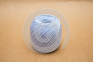 Blue yarn for knitting on brown background