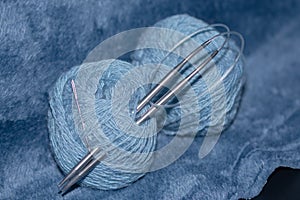 blue yarn and knitting needle on plaid