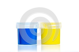 Blue and yellow jars with gouache. Hobbies and creativity. Close-up. Isolated on white background with reflection