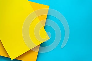 Blue and yellow pastel color papered background. Volume geometric flat lay. Top view. Copy space