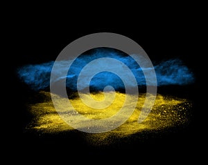 Blue and yellow powder explosion isolated on black