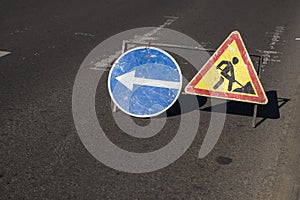 Blue and yellow-red safety signs warning about road works.The road is under construction or repair. Repair work in the