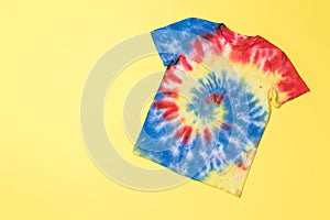 Blue-yellow-red tie dye T-shirt on a yellow background