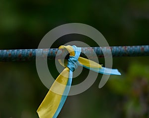 Blue and yellow silk ribbon tied on a metal tube. Ukrainian flag symbol, struggle for independence