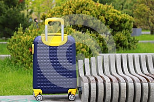 Blue yellow travel suitcase with beautiful nature, relaxing vacation, holidays, weekends and travel. Suitcase near hotel,