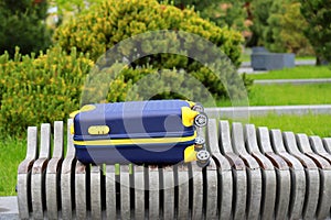Blue yellow travel suitcase with beautiful nature, relaxing vacation, holidays, weekends and travel. Suitcase near hotel,