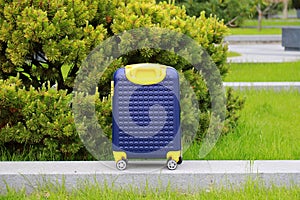 Blue yellow travel suitcase with beautiful nature, relaxing vacation, holidays, weekends and travel. Suitcase near hotel, hostel,