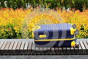 Blue yellow travel suitcase with beautiful nature, relaxing vacation, holidays, weekends and travel. Suitcase near hotel, hostel,