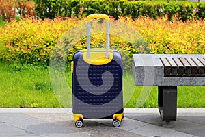 Blue yellow travel suitcase with beautiful nature, relaxing vacation, holidays, weekends and travel. Suitcase near hotel, hostel,