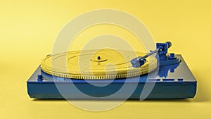 Blue and yellow vintage vinyl record player on a yellow background