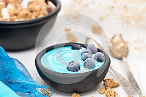 Blue yogurt with berries in the black bowl