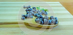 Blueberries on bamboo cutting board and wooden spoon