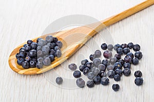 Blueberries on bamboo spoon, scattered blueberry on table